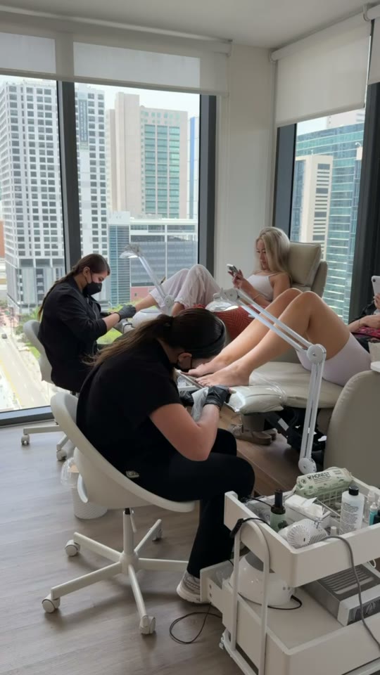 Nail technicians working with clients in the studio